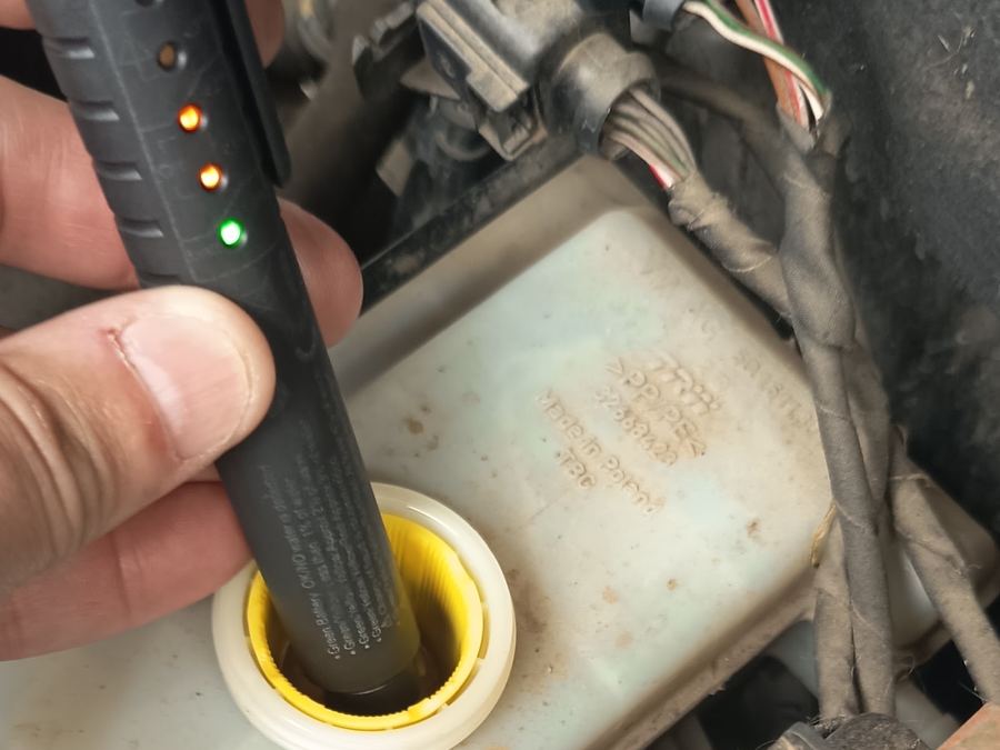 Tester midiendo el líquido de frenos en el depósito del motor