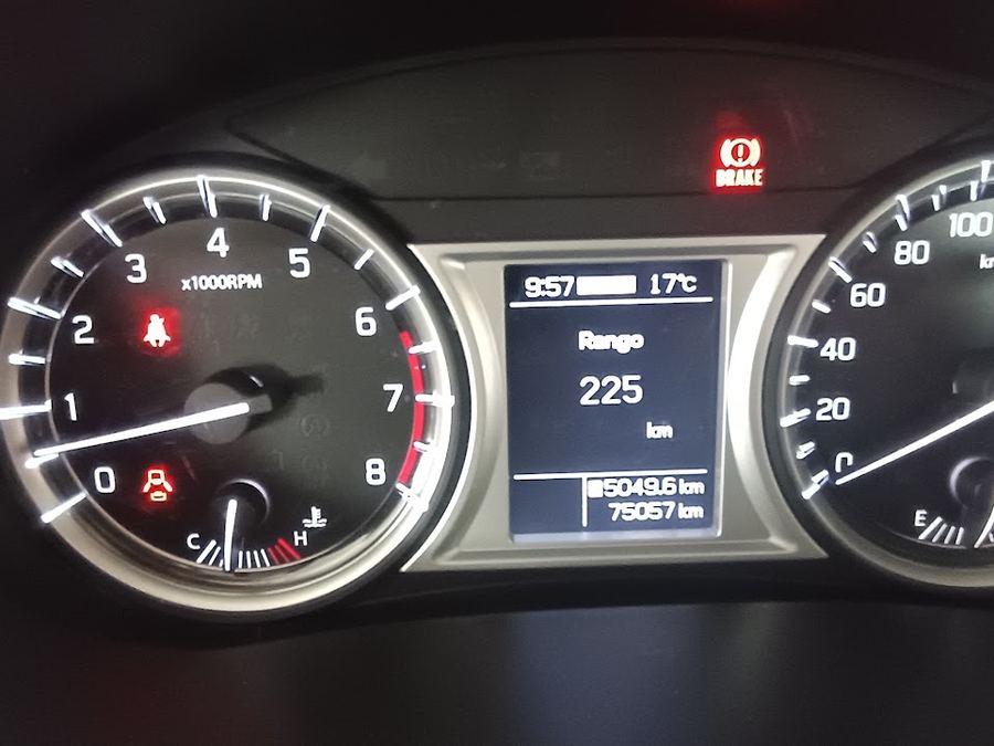 Tablero de un auto usado encendido mostrando kilometraje y testigos